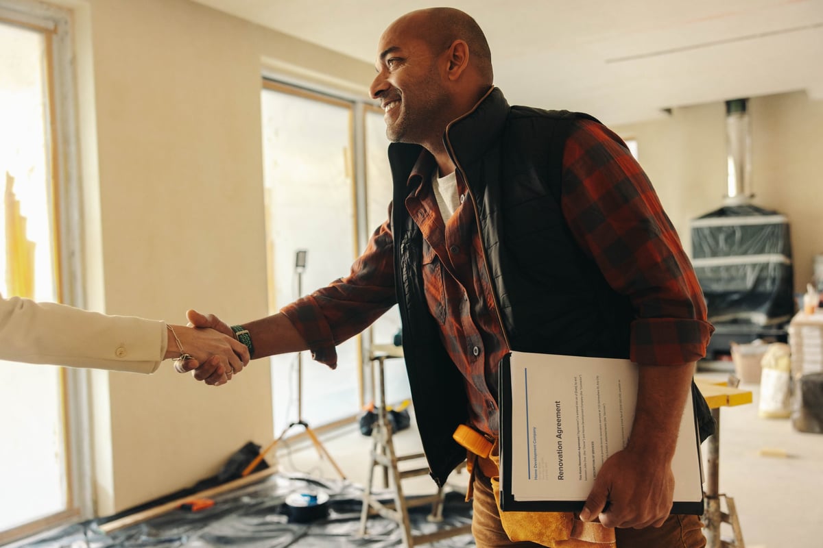 Happy contractor shaking hands with homeowner after signing renovation contract