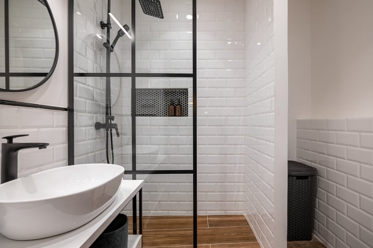 Modern bathroom renovation with white subway tiles and glass shower