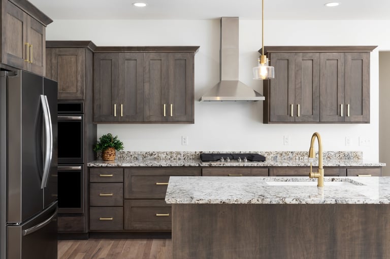 Modern kitchen renovation in Abbotsford with dark wood cabinets, granite countertops, and gold pendant lights