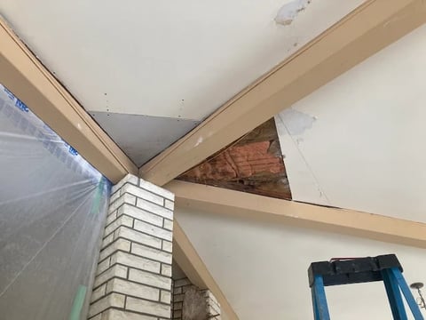 Chilliwack home renovation ceiling construction with exposed wooden beams, drywall finishing and plastic sheeting protection